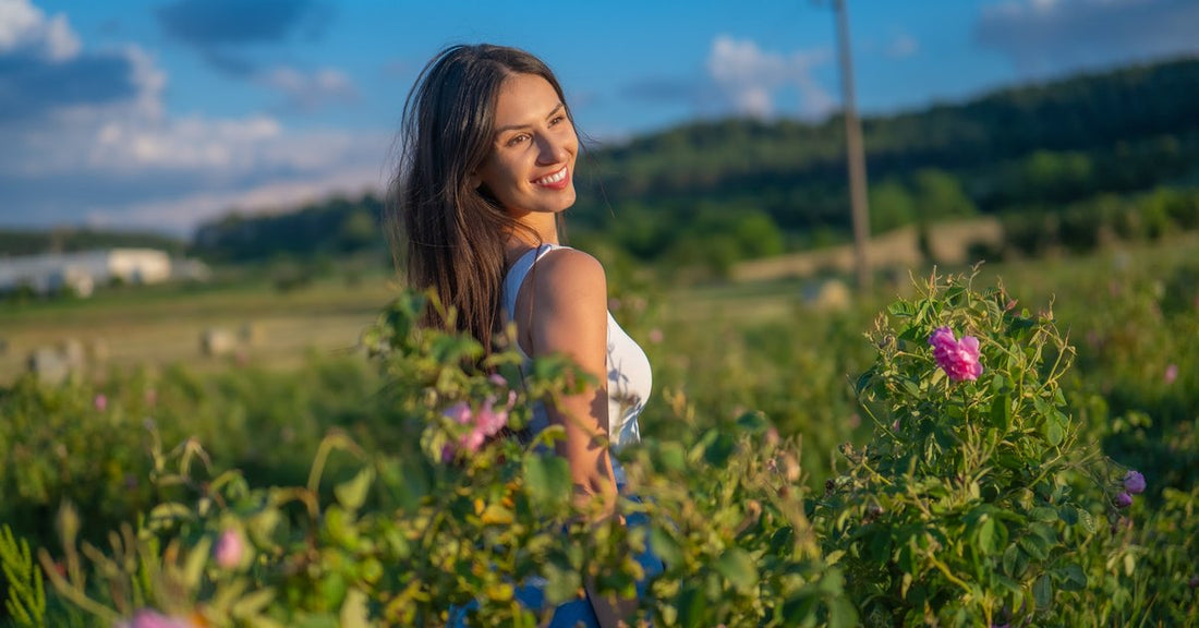 Mujer en un campo de rosas en flor en el Valle de las Rosas búlgaro