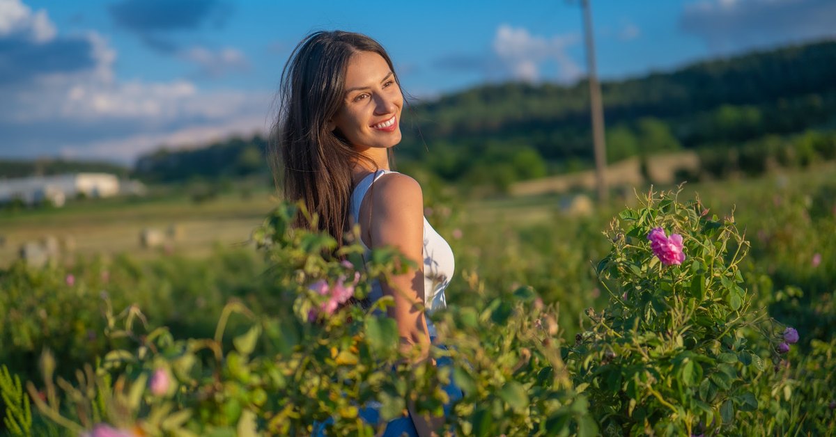 Mujer en un campo de rosas en flor en el Valle de las Rosas búlgaro