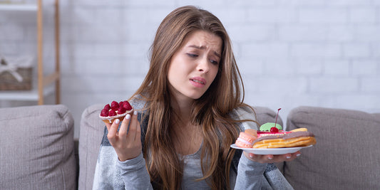 Mujer joven observando su piel con preocupación tras comer alimentos poco saludables